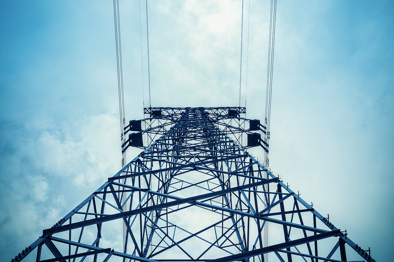 upward view of the power transmission tower in a cloudy sky

